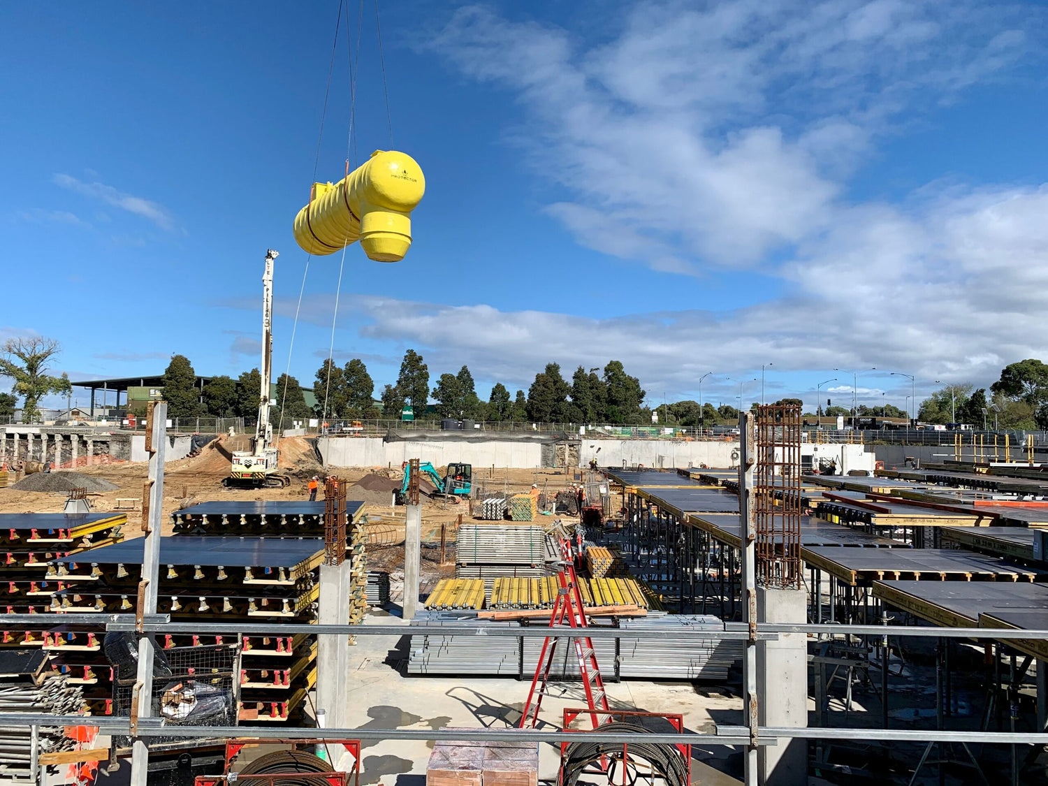 HydroProtector stormwater treatment system being lifted into position at a civil construction site for underground installation.